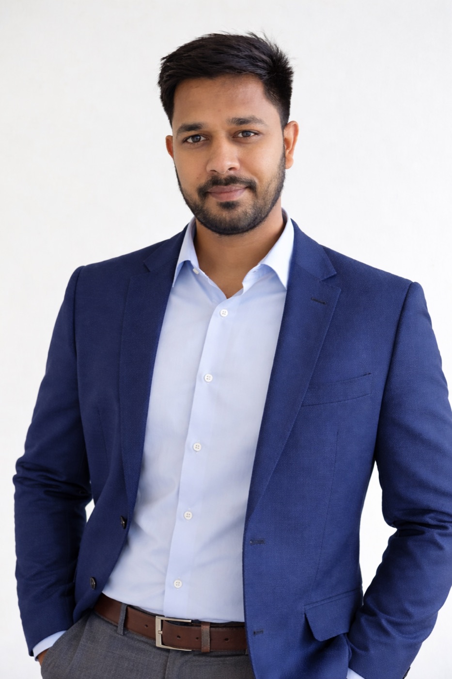 Vishal Goswami, wearing a navy blazer over a light blue shirt, against a plain white background.